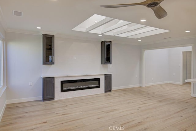 unfurnished living room with ceiling fan, light wood-type flooring, and crown molding