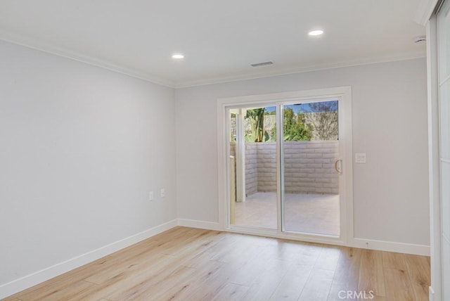 spare room featuring crown molding and light hardwood / wood-style floors