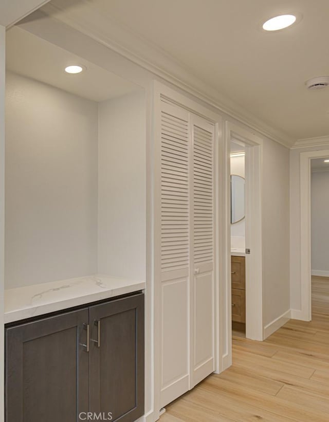 hall with crown molding and light wood-type flooring