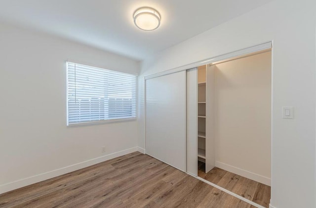 unfurnished bedroom featuring hardwood / wood-style floors and a closet