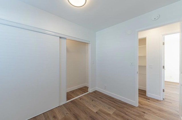 unfurnished bedroom with hardwood / wood-style flooring and a closet