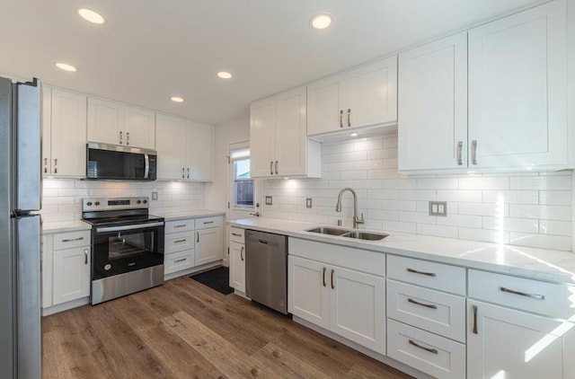 kitchen with dark hardwood / wood-style floors, stainless steel appliances, white cabinets, and sink