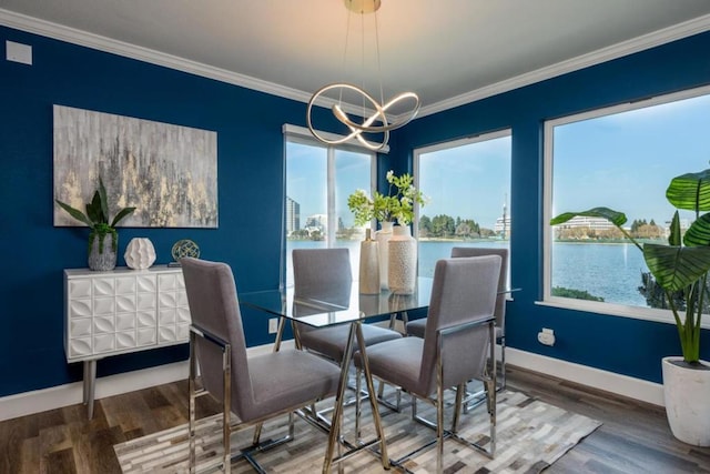 dining area featuring a water view, wood-type flooring, crown molding, and a chandelier