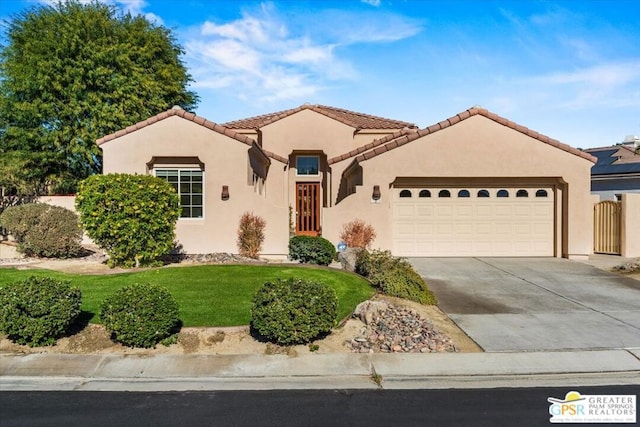 mediterranean / spanish-style house featuring a garage and a front yard