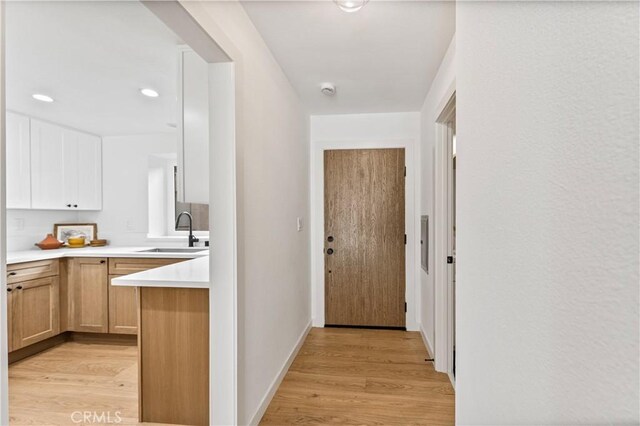 hall featuring sink and light hardwood / wood-style floors