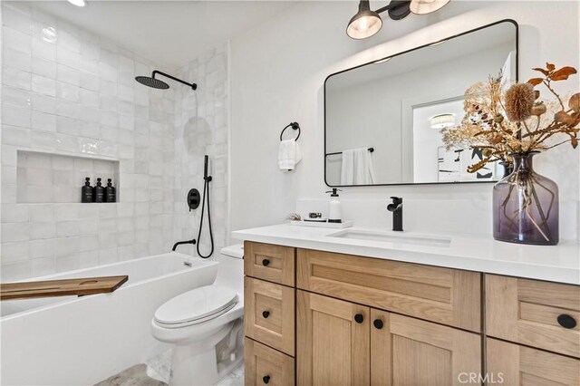 full bathroom featuring toilet, tiled shower / bath combo, and vanity