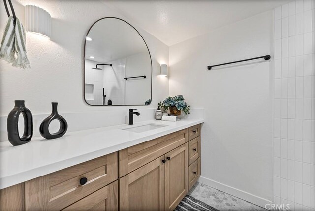 bathroom featuring walk in shower and vanity