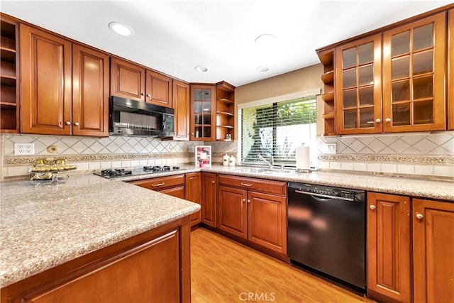 kitchen with open shelves, black appliances, a sink, and brown cabinets