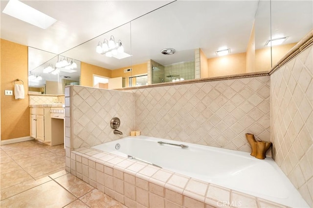 bathroom with independent shower and bath, a skylight, vanity, and tile patterned flooring