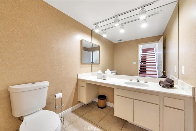 bathroom with baseboards, visible vents, toilet, tile patterned floors, and vanity