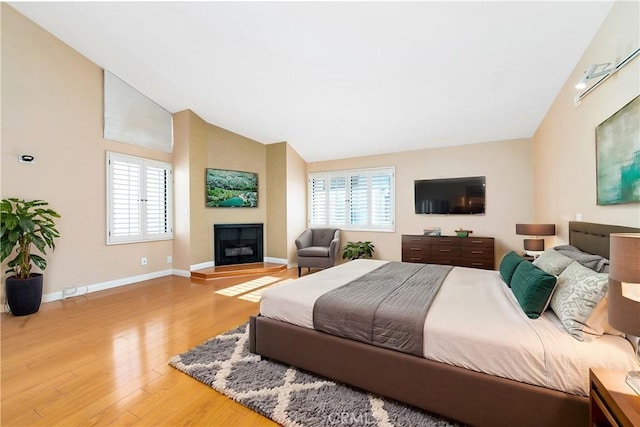 bedroom with hardwood / wood-style floors and lofted ceiling