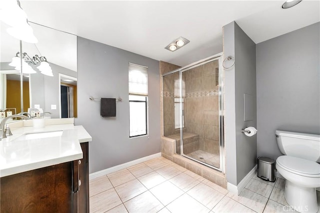 bathroom with baseboards, toilet, tile patterned floors, vanity, and a shower stall