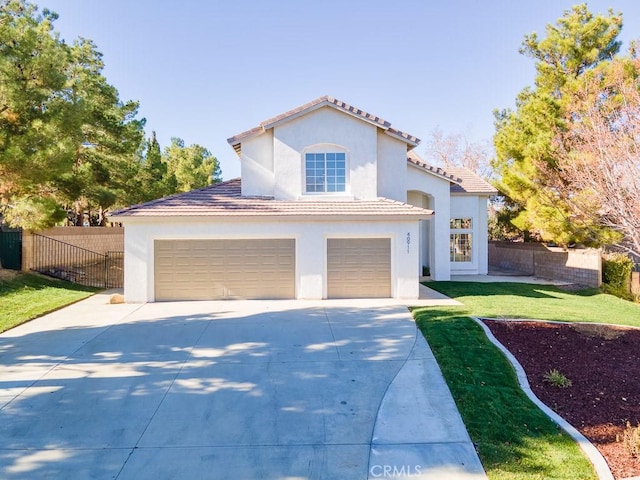 mediterranean / spanish house featuring fence, stucco siding, concrete driveway, a front lawn, and a tiled roof