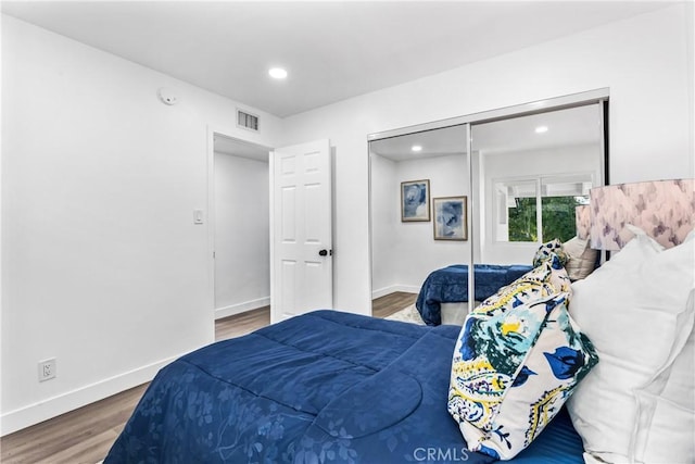 bedroom with wood-type flooring and a closet