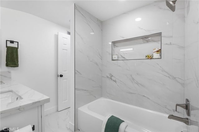 bathroom featuring tiled shower / bath and vanity