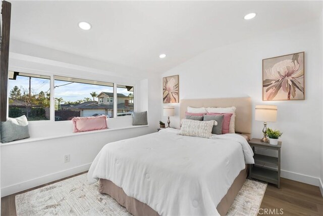 bedroom with lofted ceiling and wood-type flooring