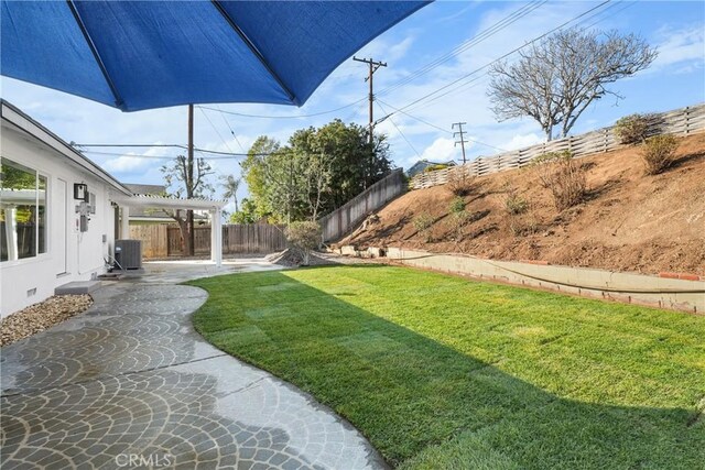 view of yard with central air condition unit, a pergola, and a patio area