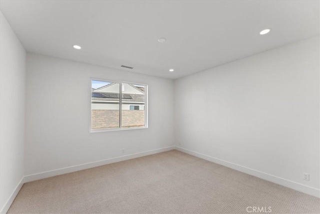 unfurnished room featuring light colored carpet