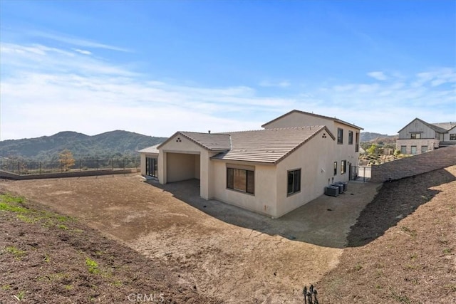 rear view of property with a mountain view and central air condition unit