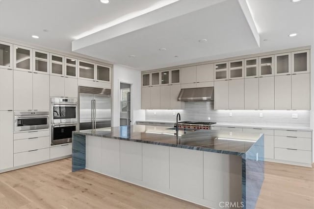 kitchen featuring a spacious island, stainless steel appliances, and white cabinets