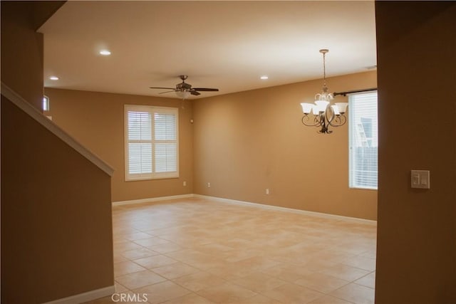 empty room featuring light tile patterned floors and ceiling fan with notable chandelier