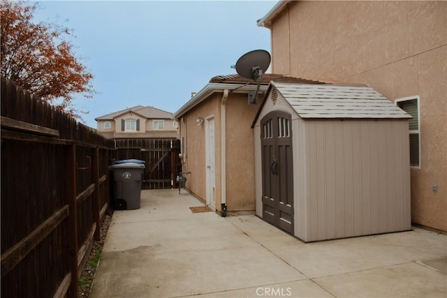 view of side of property with a patio area and a storage unit