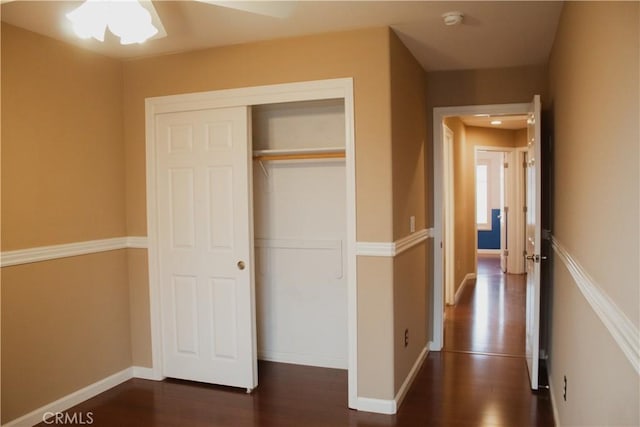 interior space featuring ceiling fan, dark hardwood / wood-style floors, and a closet