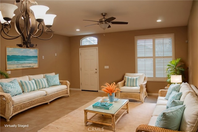 tiled living room with ceiling fan with notable chandelier and a wealth of natural light