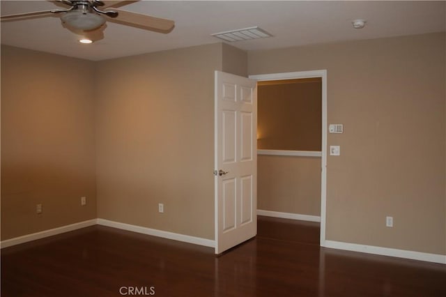 empty room with ceiling fan and dark hardwood / wood-style floors