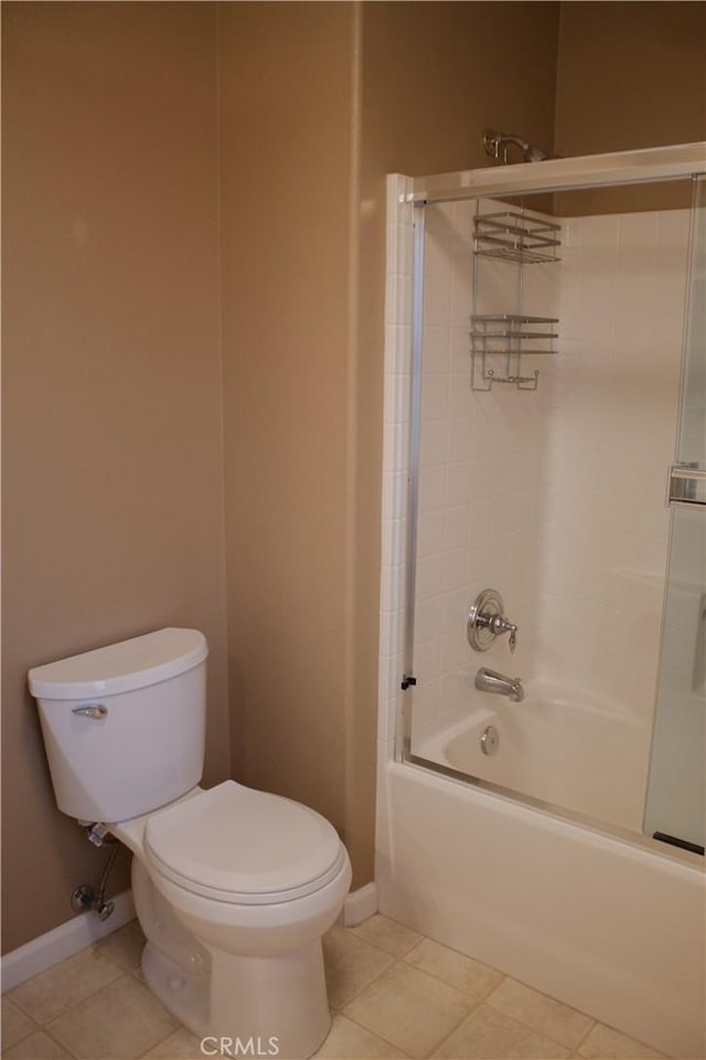 bathroom with toilet, tile patterned flooring, and shower / bath combination with glass door