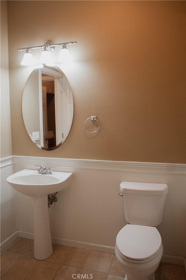 bathroom with toilet and tile patterned floors