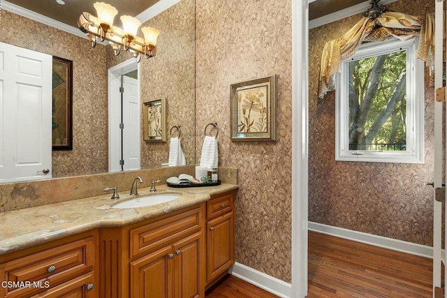 bathroom featuring hardwood / wood-style flooring, vanity, ornamental molding, and a chandelier