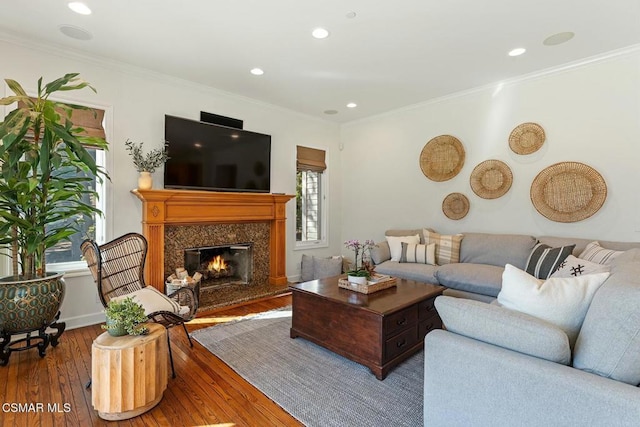 living room featuring hardwood / wood-style floors, crown molding, and a premium fireplace