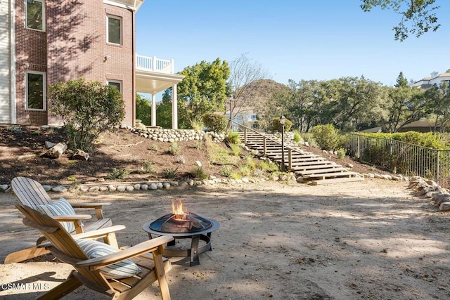 view of yard with a balcony and an outdoor fire pit