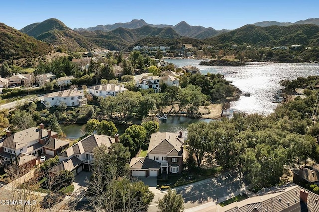 birds eye view of property with a water and mountain view