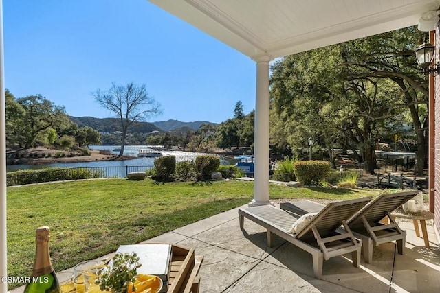 view of patio featuring a water and mountain view