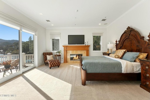 carpeted bedroom featuring a mountain view, ornamental molding, access to outside, and a fireplace