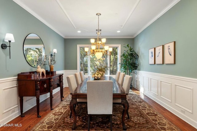 dining room with a notable chandelier, a healthy amount of sunlight, crown molding, and dark hardwood / wood-style flooring