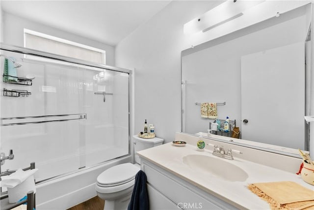 full bathroom with vanity, enclosed tub / shower combo, and toilet