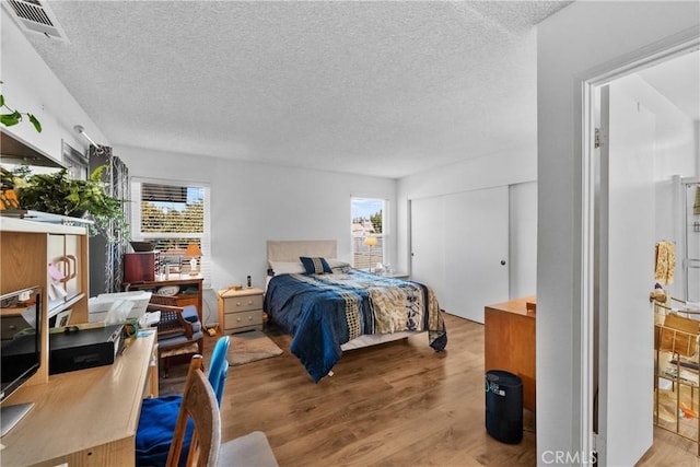 bedroom featuring a textured ceiling and light wood-type flooring