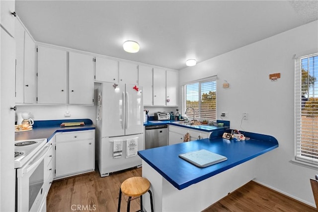 kitchen featuring white cabinetry, sink, and white appliances