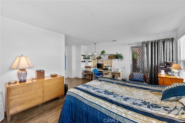 bedroom featuring wood-type flooring and a textured ceiling