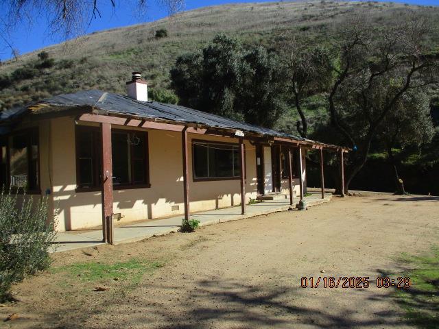 back of property featuring a patio area and a mountain view