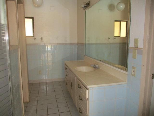 bathroom with tile patterned flooring, tile walls, and vanity