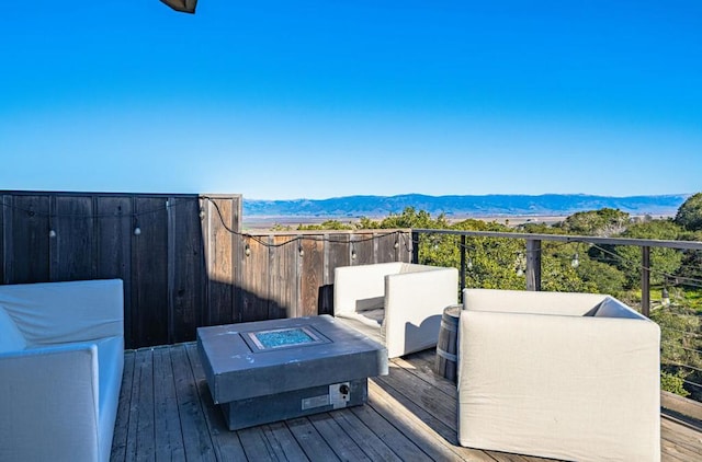 deck featuring a mountain view and a fire pit