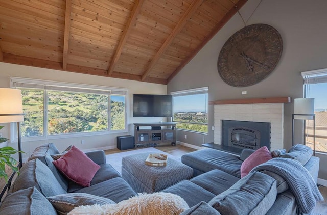 living room with a brick fireplace, a wealth of natural light, wooden ceiling, and vaulted ceiling with beams