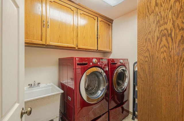 washroom with cabinets, sink, and washing machine and dryer