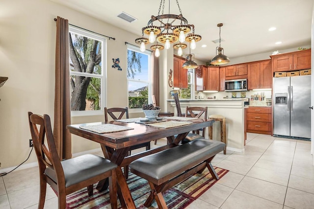 tiled dining room with a notable chandelier