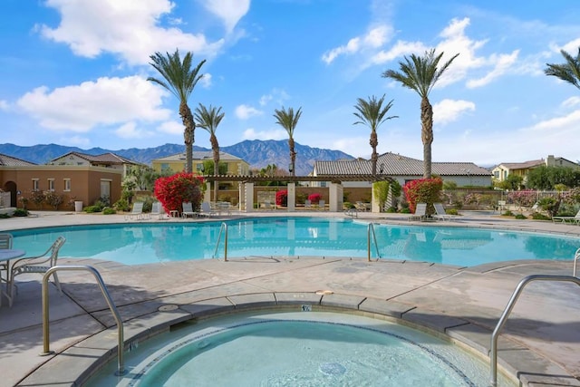 view of swimming pool featuring a mountain view and a community hot tub