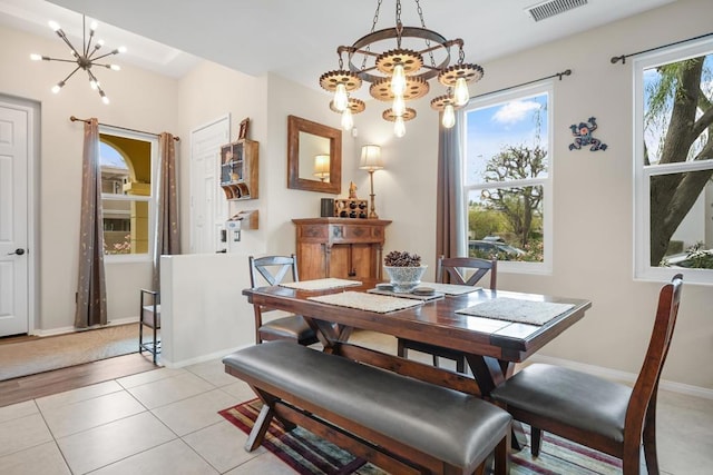 dining area with light tile patterned flooring and a notable chandelier